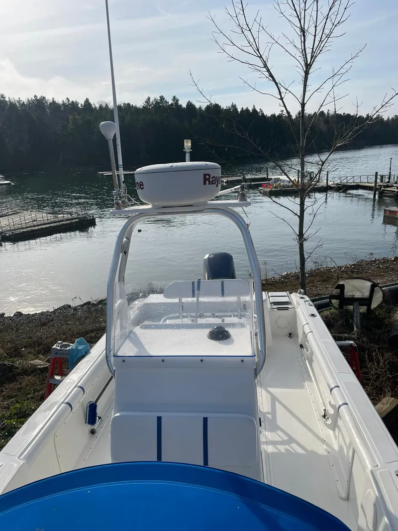 Slide: The Image of Edgewater 247CC 2000 boat docked by a serene lake with wooded shoreline. - 5