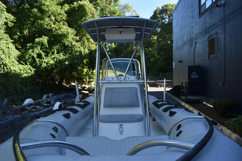 Slide: The Image of 2015 Ribcraft 7.8 boat with canopy, docked near trees and a building. - 11