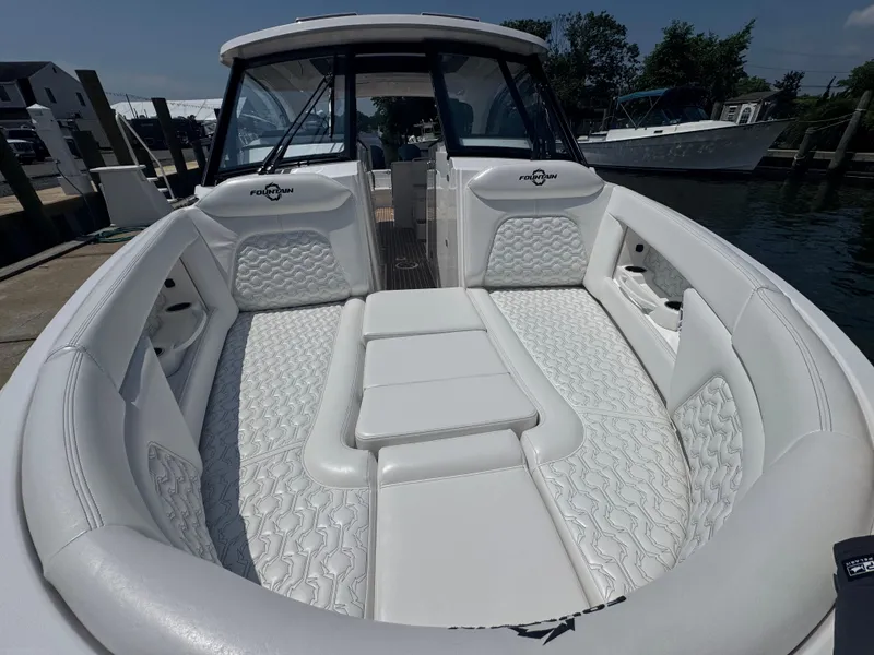 Slide: The Image of 2025 Fountain 39 DX boat with luxurious white seating and modern design at a marina. - 16