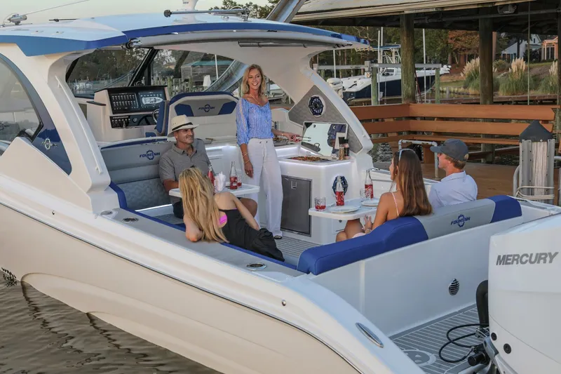 Slide: The Image of 2025 Fountain 39 DX boat with people relaxing onboard, docked near a marina. - 3