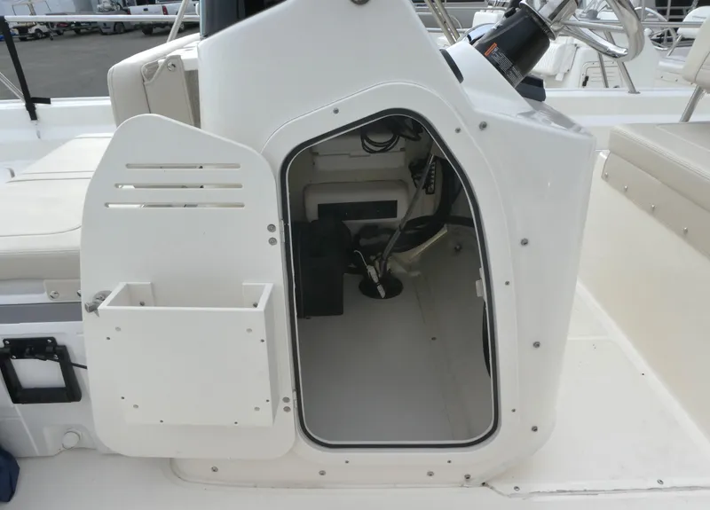 Slide: The Image of 2024 Boston Whaler 190 Montauk boat console storage compartment, open door view. - 11