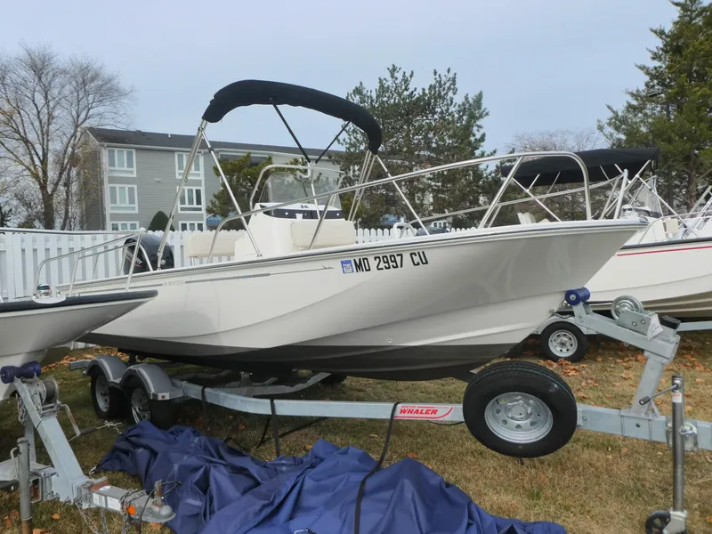 Slide: The Image of 2024 Boston Whaler 190 Montauk boat on trailer, parked outdoors. - 2