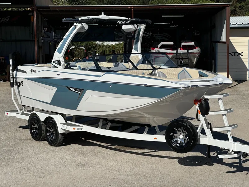 The Image of 2025 Tigé 22RZX boat on trailer, sleek design, parked outdoors. - 0