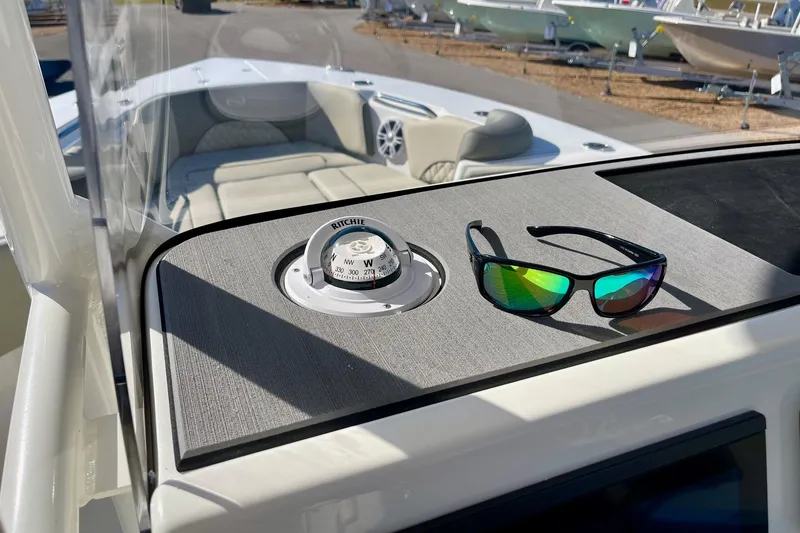 Slide: The Image of 2025 Key West 263 FS boat dashboard with compass and sunglasses. - 29