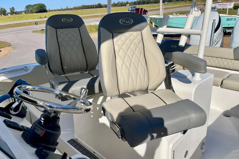 Slide: The Image of 2025 Key West 263 FS boat interior with dual gray captain seats and steering wheel. - 46