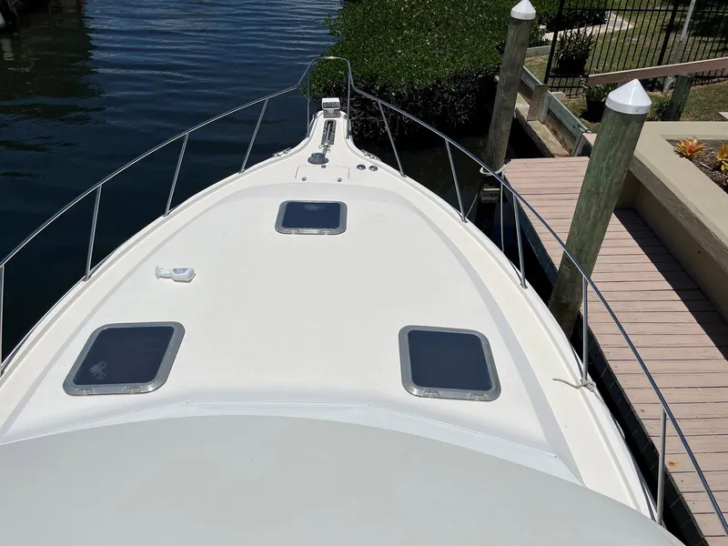 Slide: The Image of 1994 Tiara Yachts 3600 Convertible Sportfish boat docked, showing bow and deck hatches. - 17
