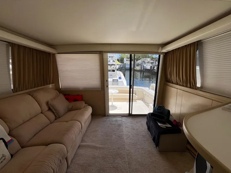 Slide: The Image of Interior of 1994 Tiara Yachts 3600 Convertible Sportfish with beige seating and marina view. - 2