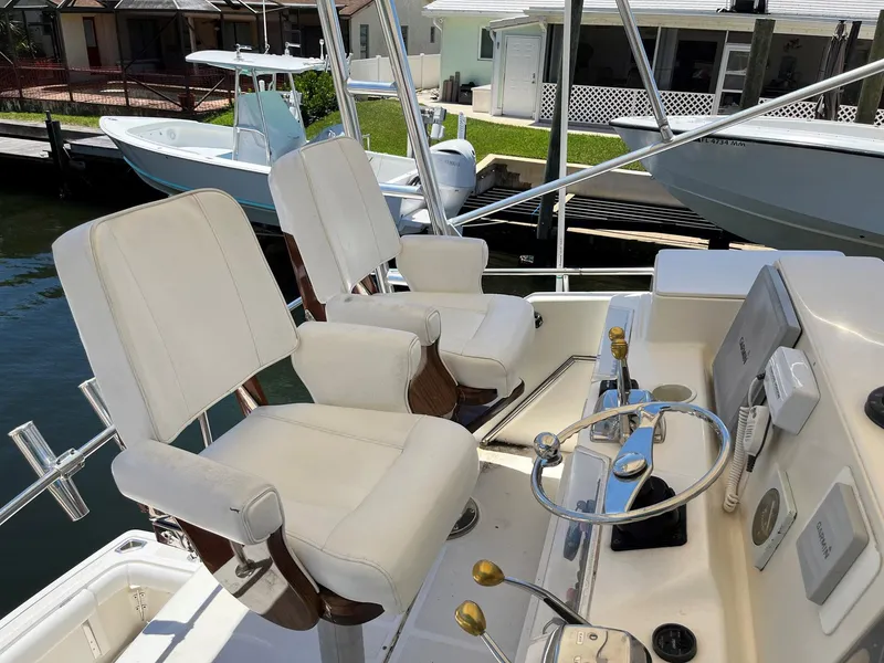 Slide: The Image of 1994 Tiara Yachts 3600 Convertible Sportfish helm with white captain chairs and control panel. - 21