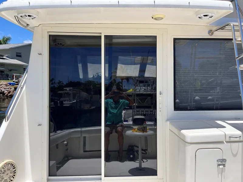 Slide: The Image of 1994 Tiara Yachts 3600 Convertible Sportfish with sliding glass doors and outdoor seating area. - 24
