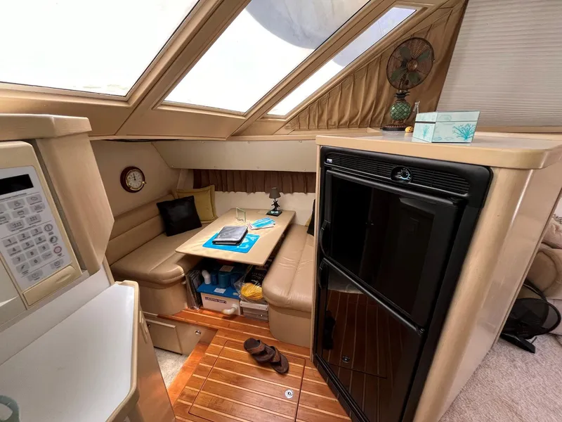 Slide: The Image of Interior of 1994 Tiara Yachts 3600 Convertible Sportfish with seating, table, and kitchenette. - 7
