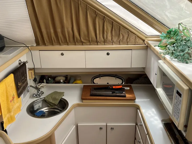 Slide: The Image of 1994 Tiara Yachts 3600 Convertible Sportfish kitchen with sink, microwave, and cutting board. - 9