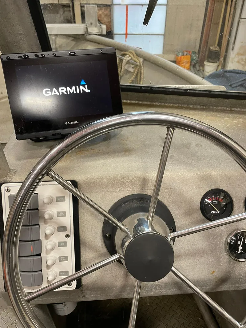 Slide: The Image of Steering wheel and Garmin display on 2003 custom work boat dashboard. - 23