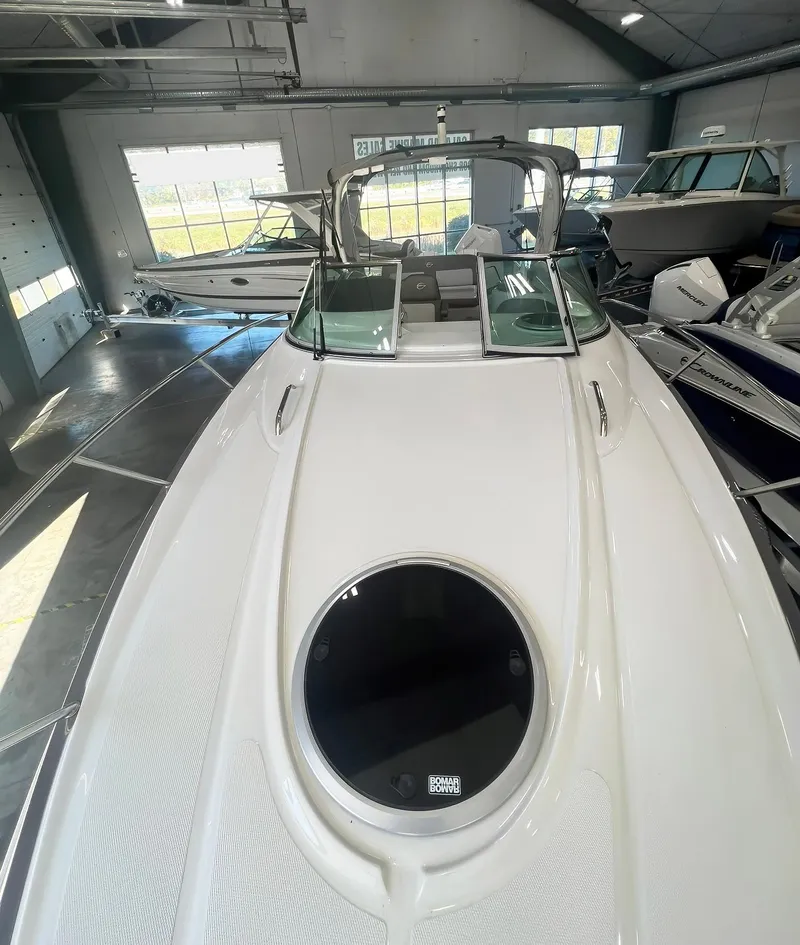 Slide: The Image of 2025 Crownline 280 CRX boat in showroom, sleek design, white exterior. - 11