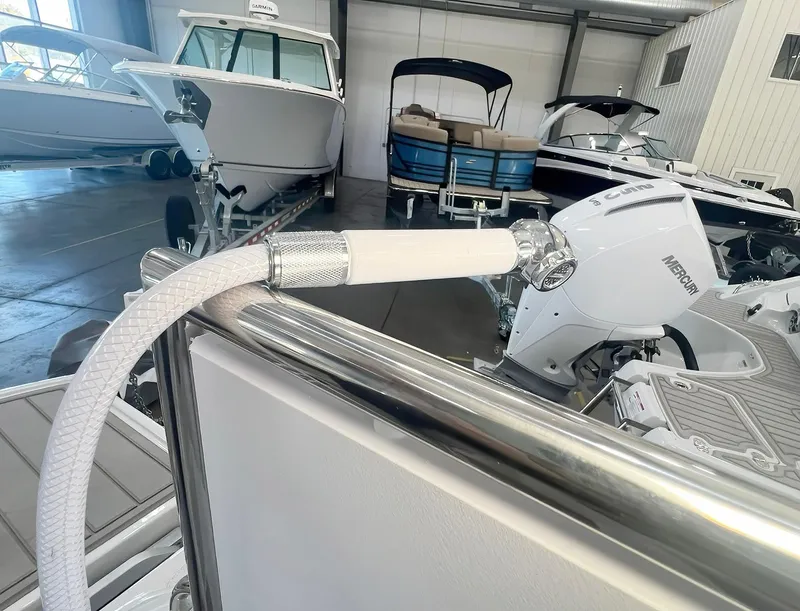 Slide: The Image of 2025 Crownline 280 CRX boat in showroom with Mercury engine and hose detail. - 19