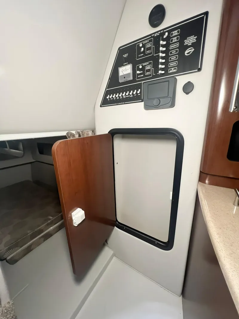 Slide: The Image of 2025 Crownline 280 CRX cabin interior with control panel and open storage compartment. - 27