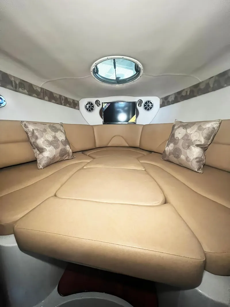 Slide: The Image of 2025 Crownline 280 CRX cabin interior with beige seating and decorative pillows. - 30