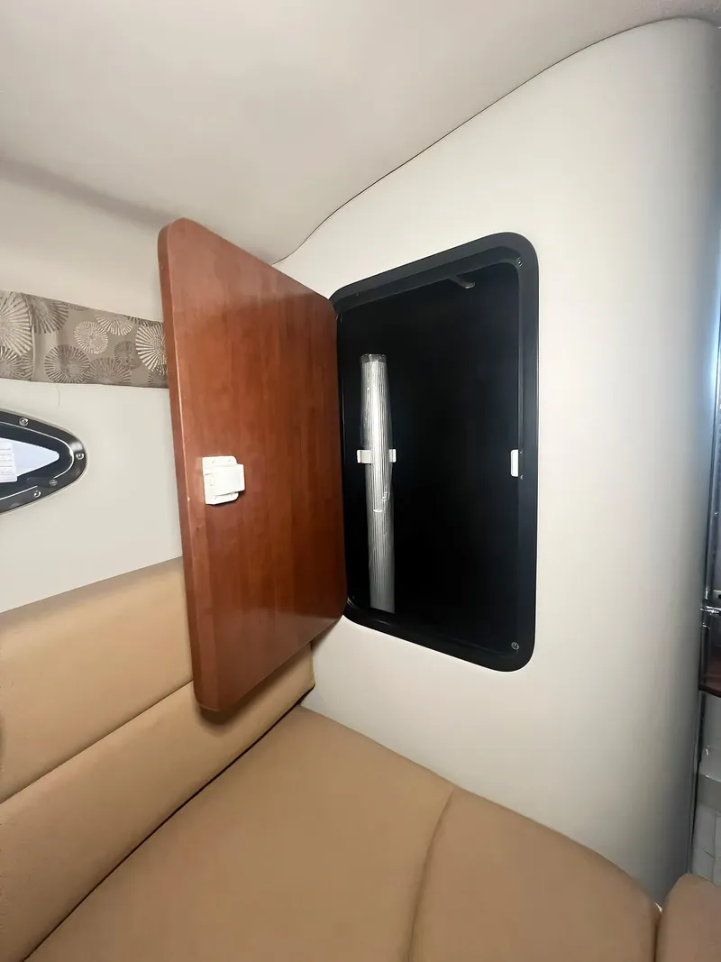 Slide: The Image of 2025 Crownline 280 CRX interior cabin with open wooden storage compartment. - 34