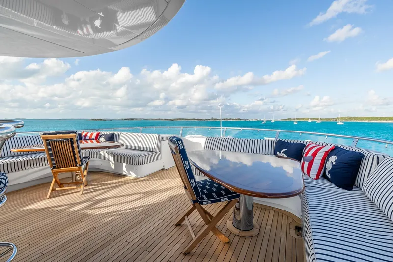 Slide: The Image of Luxurious Richmond Yachts 2007 deck with ocean view, striped seating, and wooden table. - 7