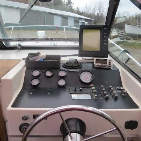 Slide: The Image of 1973 Slickcraft SS235 boat dashboard with gauges, steering wheel, and navigation equipment. - 19