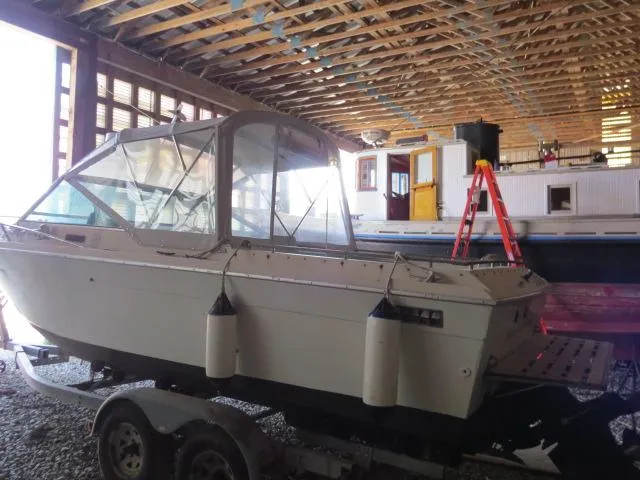 Slide: The Image of 1973 Slickcraft SS235 boat on trailer in a wooden boathouse. - 23