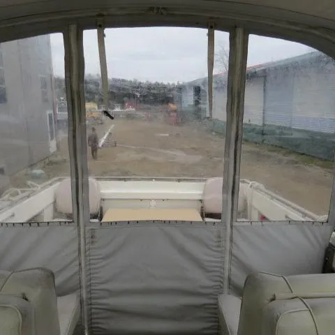 Slide: The Image of 1973 Slickcraft SS235 boat interior with covered seating and clear windows. - 4