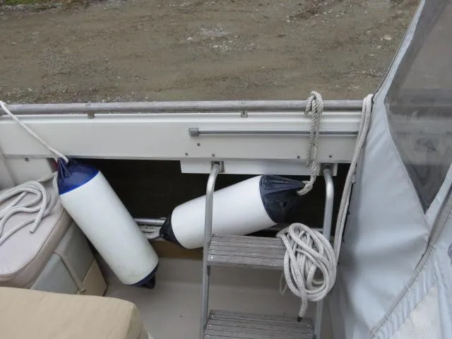 Slide: The Image of 1973 Slickcraft SS235 boat interior with fenders and ropes near a ladder. - 8