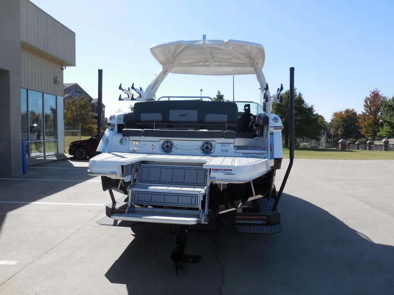 Slide: The Image of 2025 Chaparral 26 Surf boat, rear view, parked outdoors on a sunny day. - 4