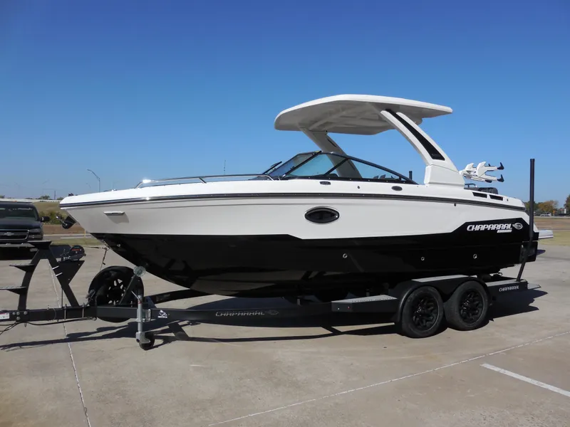 Slide: The Image of 2025 Chaparral 26 Surf boat on trailer, sleek design, parked outdoors. - 6