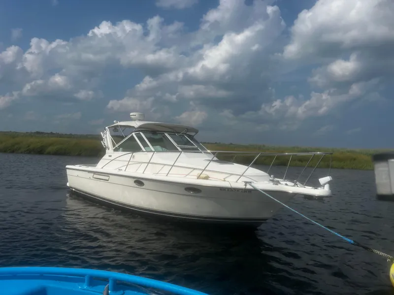 Slide: The Image of 1995 Tiara Yachts 2900 Open boat on calm water under cloudy sky. - 1