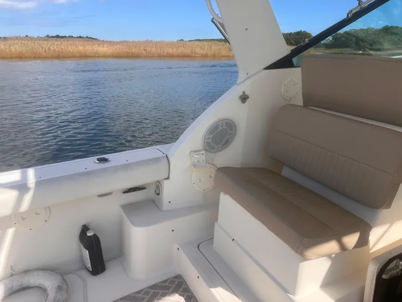 Slide: The Image of 1995 Tiara Yachts 2900 Open interior with seating, near serene water and reeds. - 11