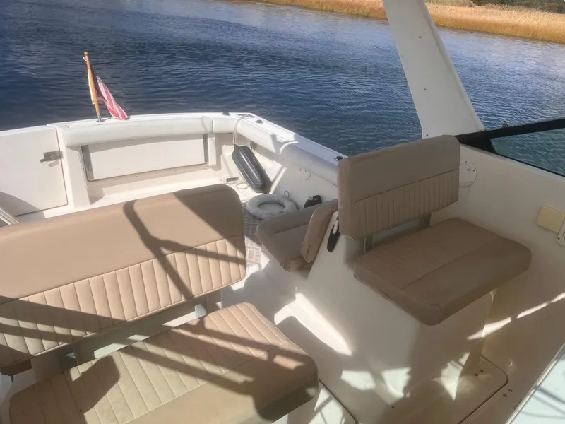 Slide: The Image of 1995 Tiara Yachts 2900 Open interior with beige seating, overlooking calm water. - 12
