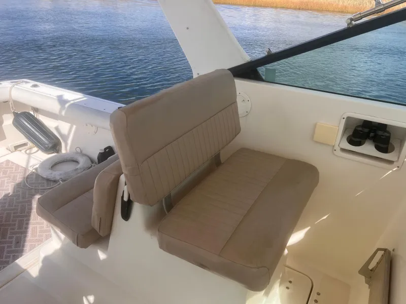 Slide: The Image of 1995 Tiara Yachts 2900 Open interior with beige seating and water view. - 16