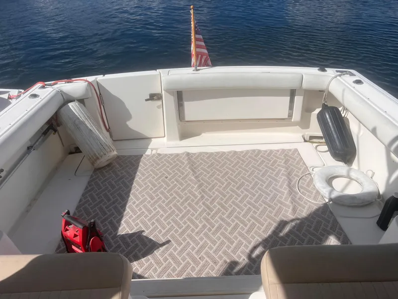 Slide: The Image of 1995 Tiara Yachts 2900 Open deck with seating, American flag, and nautical accessories. - 18