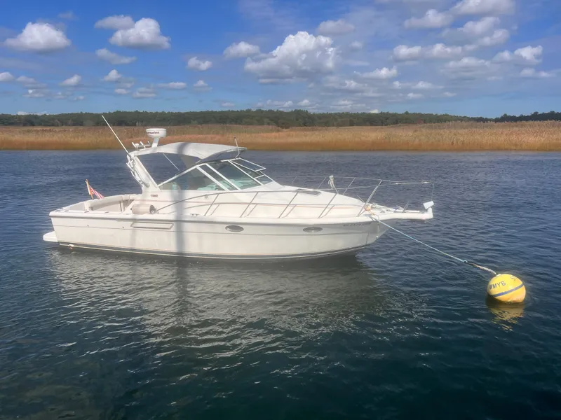 Slide: The Image of 1995 Tiara Yachts 2900 Open boat anchored on calm water under a blue sky. - 2