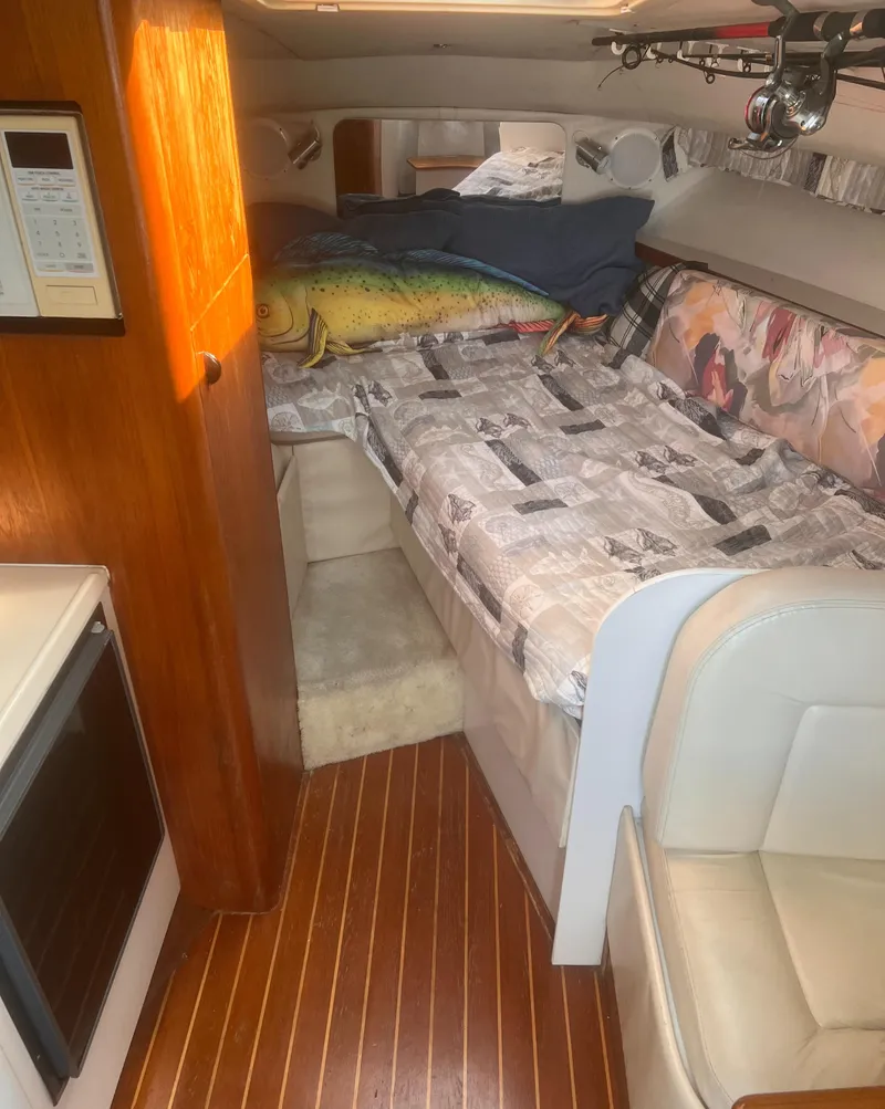 Slide: The Image of 1995 Tiara Yachts 2900 Open cabin interior with bed, wood flooring, and seating area. - 22