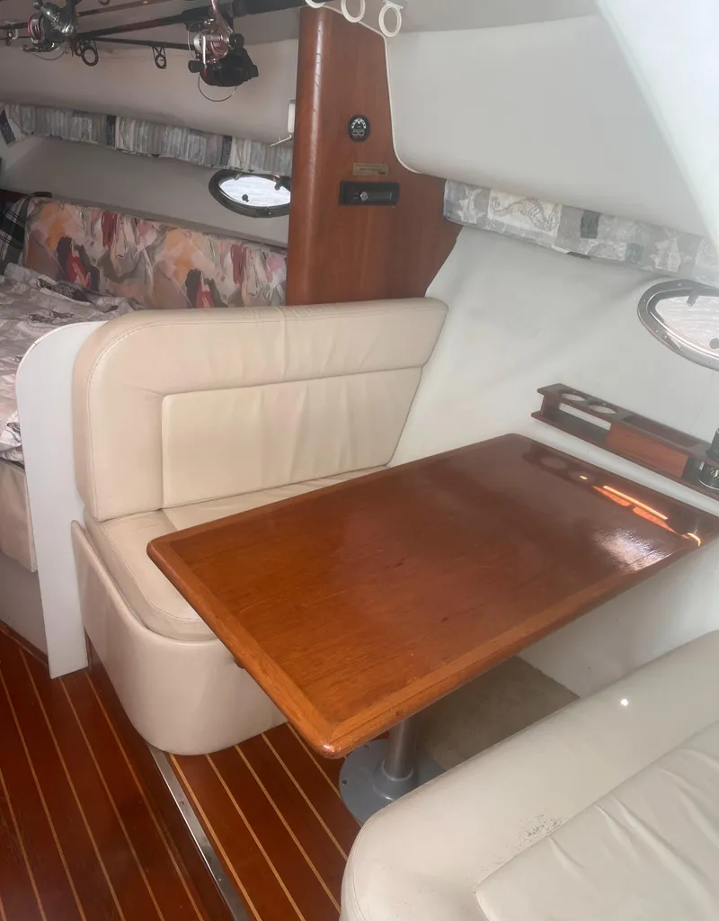 Slide: The Image of 1995 Tiara Yachts 2900 Open interior with wooden table and beige seating. - 24