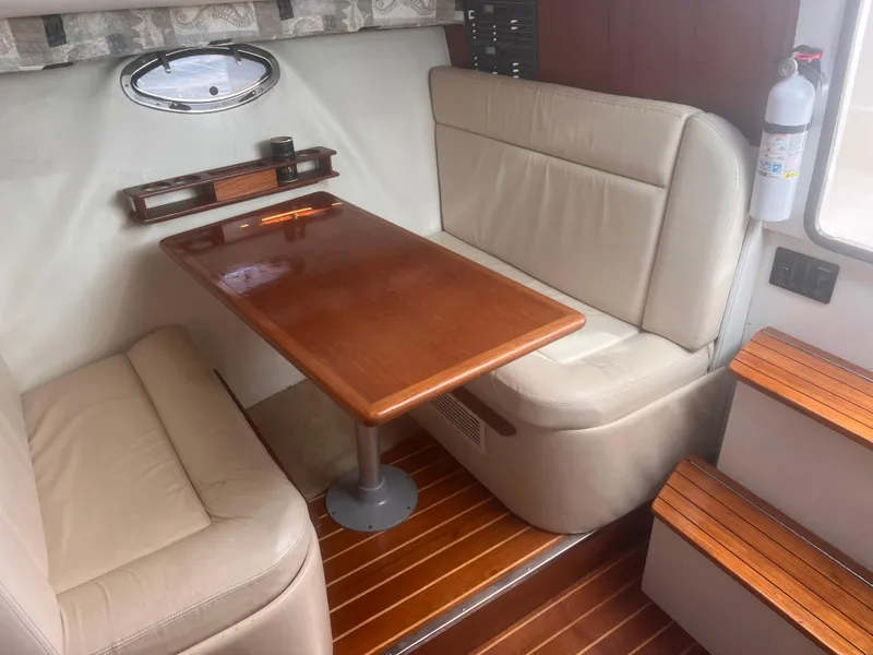Slide: The Image of 1995 Tiara Yachts 2900 Open interior with wooden table and beige seating. - 25