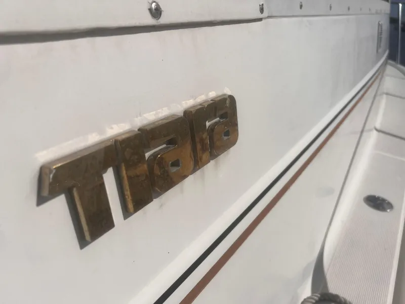 Slide: The Image of 1995 Tiara Yachts 2900 Open, close-up of gold logo on white hull. - 8