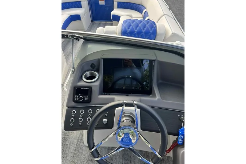 Slide: The Image of 2025 Bennington 25QXSBWA boat dashboard with steering wheel and modern controls. - 19