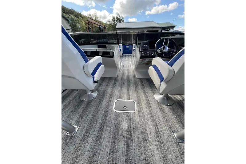 Slide: The Image of Interior of 2025 Bennington 25QXSBWA boat with modern seating and steering wheel. - 20