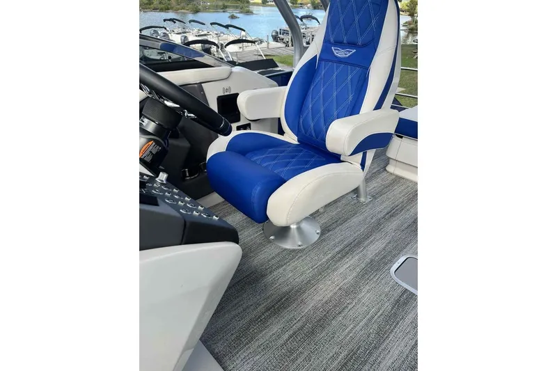 Slide: The Image of Luxury captain's chair on 2025 Bennington 25QXSBWA boat, featuring blue and white upholstery. - 24