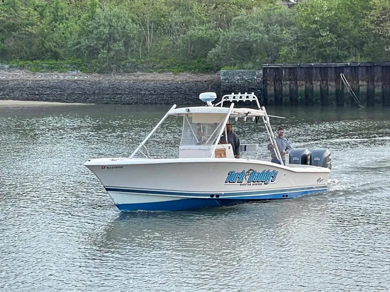 Slide: The Image of 1989 Rybo Runner Center Console boat cruising on a calm river near a wooded shoreline. - 23