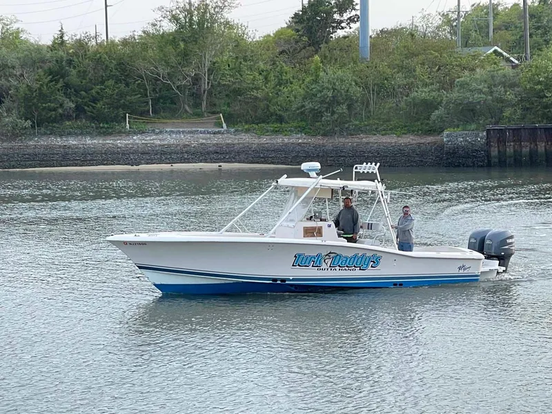 Slide: The Image of 1989 Rybo Runner Center Console boat on calm water near a wooded shoreline. - 24