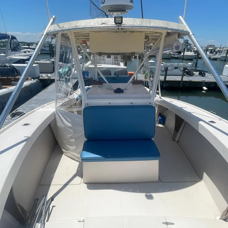 Slide: The Image of 1989 Rybo Runner Center Console boat docked at marina, featuring blue seating. - 5
