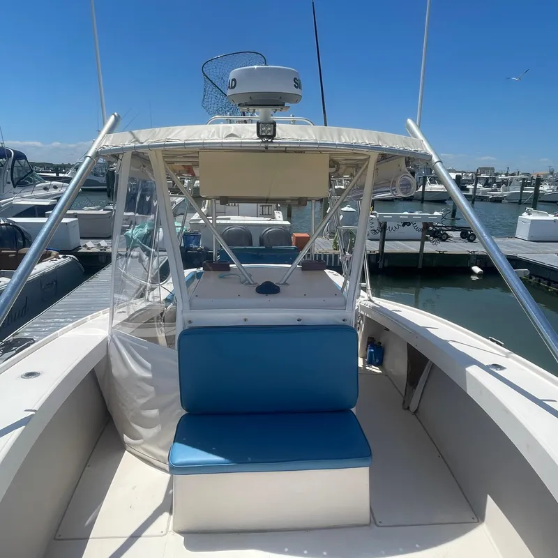Slide: The Image of 1989 Rybo Runner Center Console boat docked at marina under clear blue sky. - 6