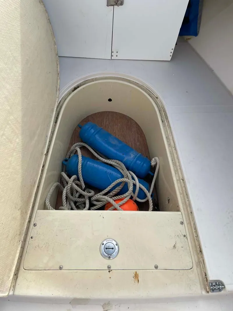 Slide: The Image of 1989 Rybo Runner Center Console storage compartment with ropes and fenders. - 7