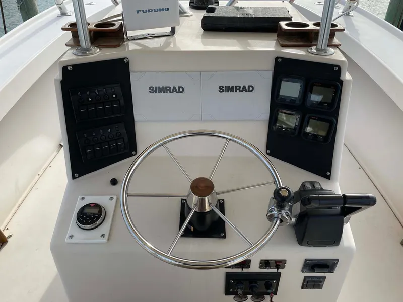 Slide: The Image of 1989 Rybo Runner Center Console boat dashboard with steering wheel and navigation equipment. - 9