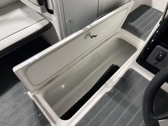 Slide: The Image of 2025 Yamaha Boats AR190 interior storage compartment with open lid. - 19