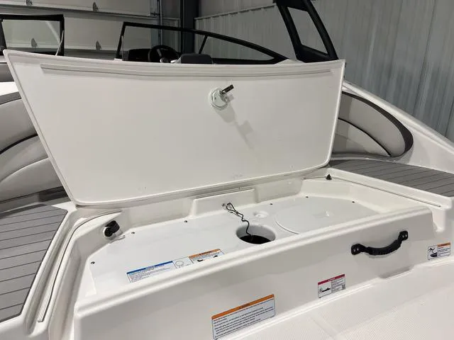 Slide: The Image of 2025 Yamaha Boats AR190 storage compartment open in sleek white interior. - 4