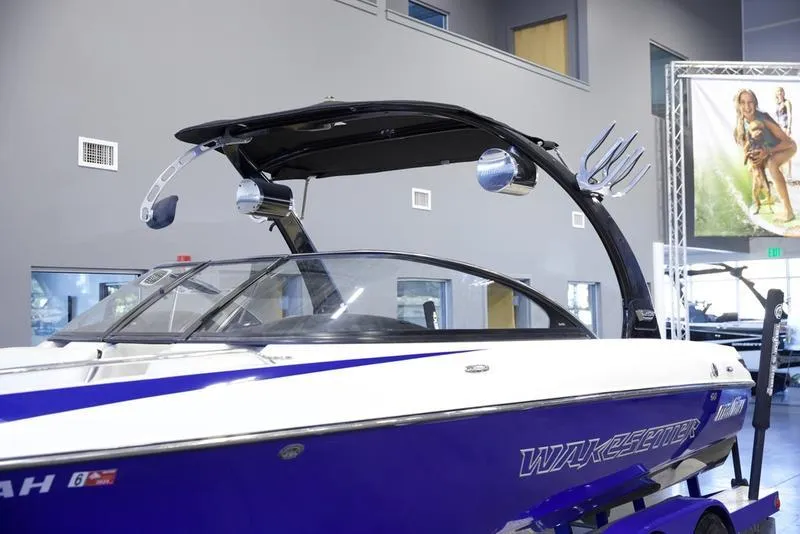 Slide: The Image of 2008 Malibu 21 VLX Wakeboard Boat in showroom, featuring sleek design and vibrant blue color. - 11